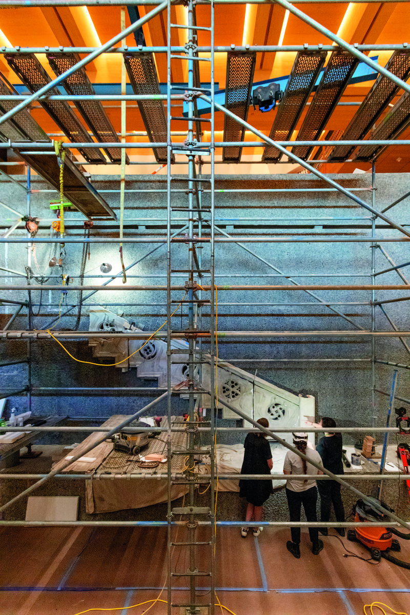 View of scaffolding with a part of a stone staircase in the background being installed.